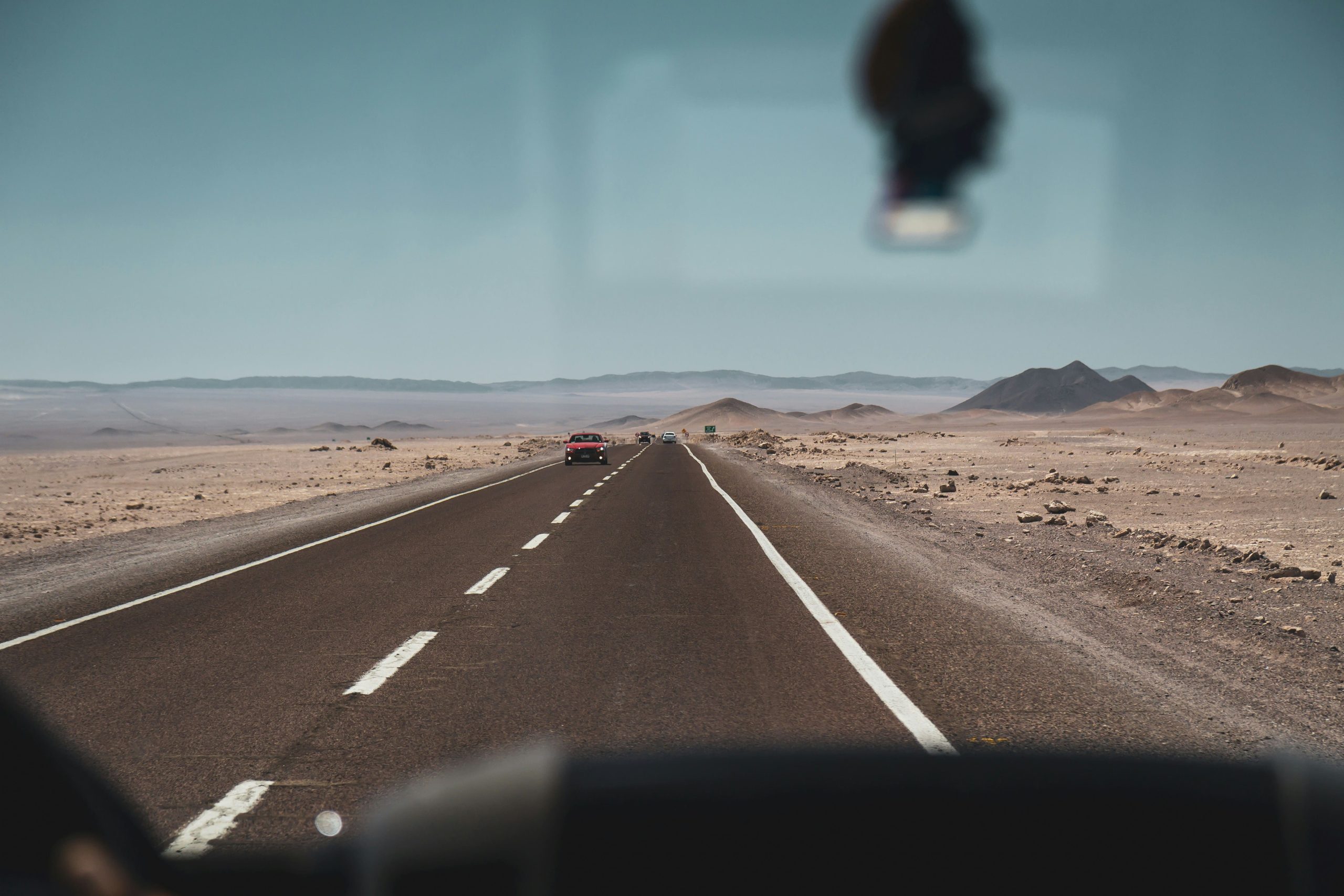 Carretera asfáltica recta cruzando el desierto bajo un cielo despejado.
